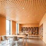 Library with Murano perforated timber acoustic panels on ceiling and walls, reducing echo and enhancing warmth.