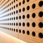 Close-up view of Murano perforated timber acoustic panels showing round holes and precise craftsmanship for sound absorption.